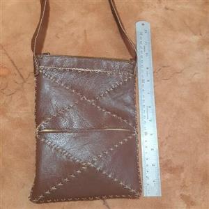 کیف چرم طبیعی بزقهوه ای دستدوز تکه دوزی شده درابعاد17در23دریک سانتیمتربابند2در120سانتیمتری دارای3جیب ساده و3جیب زیپی