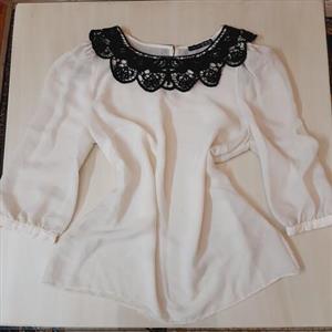 شومیز مجلسی مارک Atmosphere رنگ سفید با یقه قلاب بافی مشکی