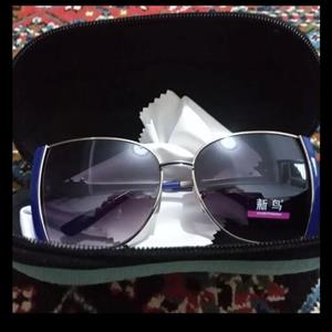 عینک آفتابی زنانه عدسیuy400  سایز بزرگ  رنگ نقره ای آبی مایل به سرمه ای همراه با جلد زیپی و دستمال عینک