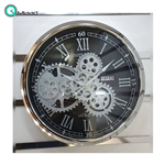 ساعت دیواری اویسا مدل 401، ساعت دیواری ساخته شده با بدنه فلزی، دارای چرخ دنده متحرک روی صفحه ساعت، اعداد رومی، رنگ نقره ای با آبکاری فورتیک، سایز 45