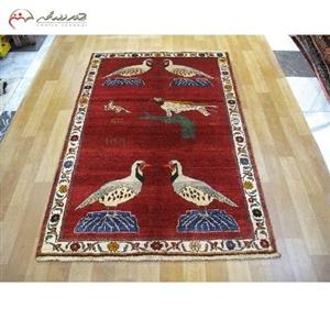 فرش دستبافت گبه طرح باغ پرنده با رنگ زمینه ی لاکی و حاشیه کرم، بافته شده ظرافت بالا کد 39764 