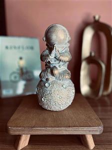 مجسمه فضانورد نشسته‌ی رو ماه